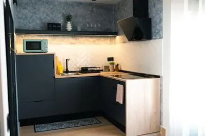 a small kitchen with black cabinets and a microwave at El Olivar de Baro in Jerez de la Frontera