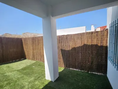 a room with a brick wall and green grass at Casa Las Piletas in Sanlúcar de Barrameda