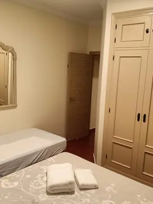 a bedroom with two beds and a mirror and a door at Casa Villa Lydia en el centro de Chipiona in Chipiona