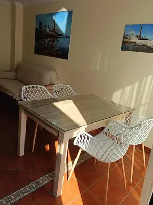 a dining room table with chairs and a couch at Casa Villa Lydia en el centro de Chipiona in Chipiona