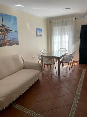 a living room with a couch and a table and chairs at Casa Villa Lydia en el centro de Chipiona in Chipiona