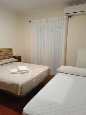 a bedroom with two beds and a window at Casa Villa Lydia en el centro de Chipiona in Chipiona