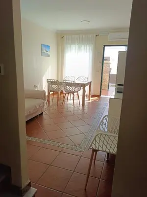 a living room with a couch and a table and chairs at Casa Villa Lydia en el centro de Chipiona in Chipiona
