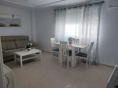 a living room with a table and chairs and a couch at Apartamento Plaza Alta in Sanlúcar de Barrameda