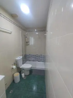 a white bathroom with a toilet and a shower at Apartamento Plaza Alta in Sanlúcar de Barrameda