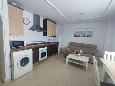 a kitchen with a washing machine and a couch at Apartamento Plaza Alta in Sanlúcar de Barrameda