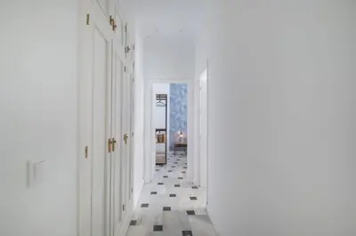 a hallway with white walls and a floor with tiles at Cadizz- Andalusian Green Palace - ideal familias centro del Puerto Santa María in El Puerto de Santa María