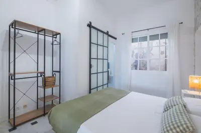 a bedroom with a bed and a book shelf at Cadizz- Andalusian Green Palace - ideal familias centro del Puerto Santa María in El Puerto de Santa María