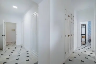 a hallway with white walls and black and white tile floors at Cadizz- Andalusian Green Palace - ideal familias centro del Puerto Santa María in El Puerto de Santa María