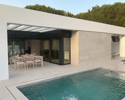 a house with a pool and a table and chairs at Esmeralda Sea Villa - Beach&Golf Sancti Petri in Novo Sancti Petri