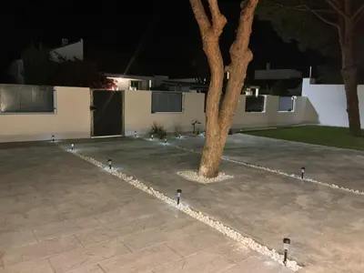 a courtyard with a tree and lights in front of a house at Esmeralda Sea Villa - Beach&Golf Sancti Petri in Novo Sancti Petri