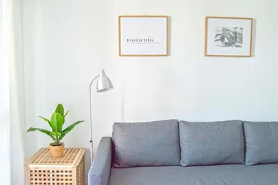 a living room with a blue couch and a lamp at Pinar de la Almadraba, Apartamentos Living Sur in Rota