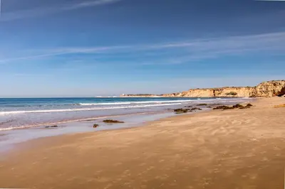 a beach with rocks in the water and the ocean at Grupotel Conil Playa - Adults Only Recommended in Conil de la Frontera