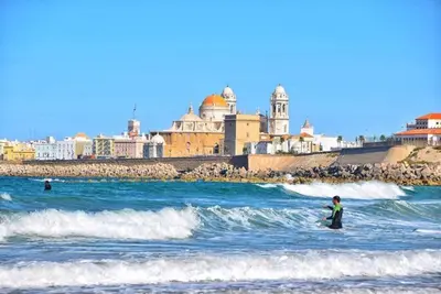 a person standing in the water in the ocean at Apartamento Hibiscos Little Apartments in Cádiz