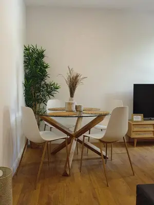 a dining room with a table and white chairs at Apartamento Hibiscos Little Apartments in Cádiz