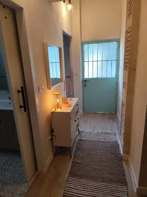 a hallway with a door and a dresser with a mirror at Maktub Medina in Medina Sidonia