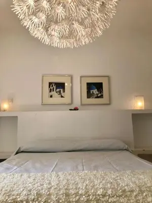 a bedroom with a large chandelier above a bed at Lazzy House in Hozanejos
