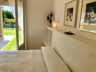 a white bedroom with a bed and a window at Lazzy House in Hozanejos
