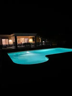 a swimming pool lit up at night at Lazzy House in Hozanejos