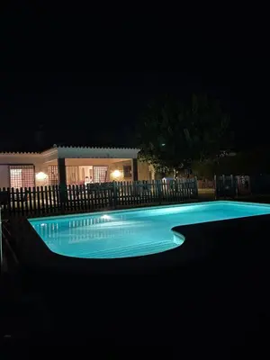 a swimming pool lit up at night at Lazzy House in Hozanejos