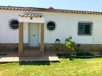 a white house with a hose in the yard at Lazzy House in Hozanejos