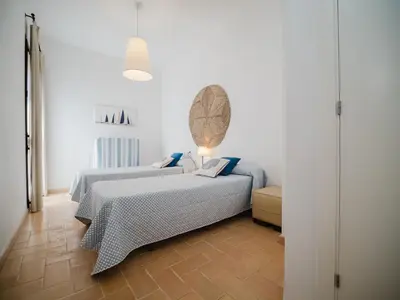 a bedroom with two beds with blue pillows at Sibs Sanlucar Fariñas 11-15 - Historical building in Sanlúcar de Barrameda