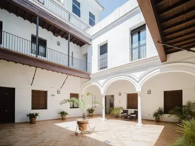 an empty courtyard in a building with plants at Sibs Sanlucar Fariñas 11-15 - Historical building in Sanlúcar de Barrameda