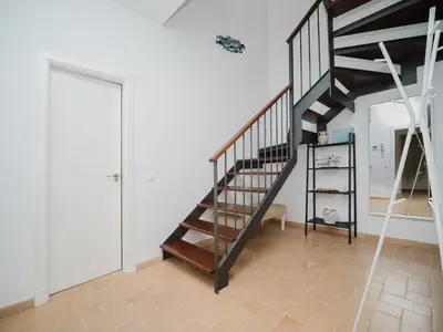 a staircase in a room with a white wall at Sibs Sanlucar Fariñas 11-15 - Historical building in Sanlúcar de Barrameda