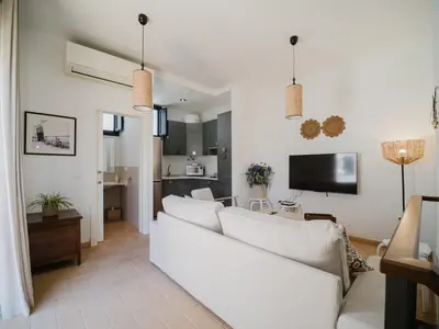 a living room with a white couch and a tv at Sibs Sanlucar Fariñas 11-15 - Historical building in Sanlúcar de Barrameda