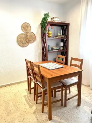 a wooden dining room table with chairs and a shelf at El Viñero, Apartamento con garaje in Cádiz