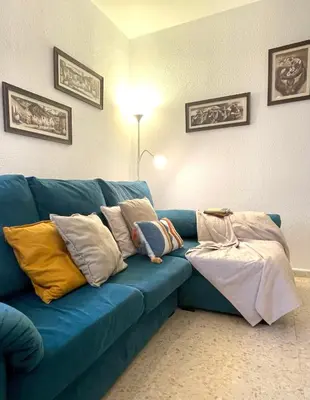a blue couch with pillows on it in a living room at El Viñero, Apartamento con garaje in Cádiz