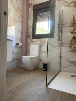 a bathroom with a toilet and a glass shower at La Cuesta in Chiclana de la Frontera