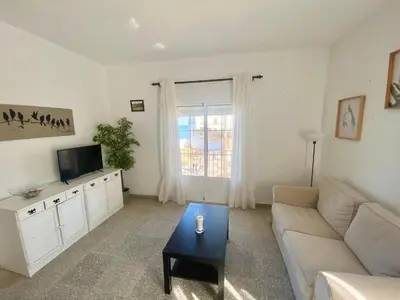 a living room with a couch and a tv at Magnifico alojamiento a 14 metros de la playa con magnificas vistas in Chipiona