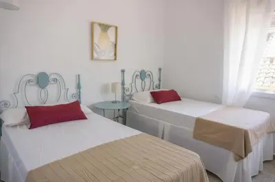 a room with two beds and a table in it at Magnifico alojamiento a 14 metros de la playa con magnificas vistas in Chipiona