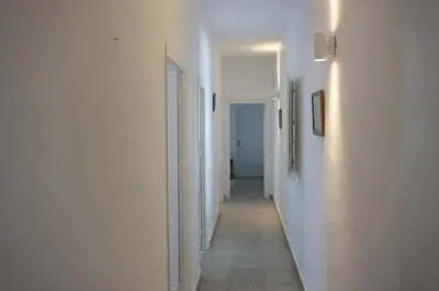 a hallway with white walls and a long hallway with white ceilings at Magnifico alojamiento a 14 metros de la playa con magnificas vistas in Chipiona