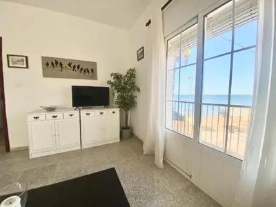 a living room with a television and a large window at Magnifico alojamiento a 14 metros de la playa con magnificas vistas in Chipiona