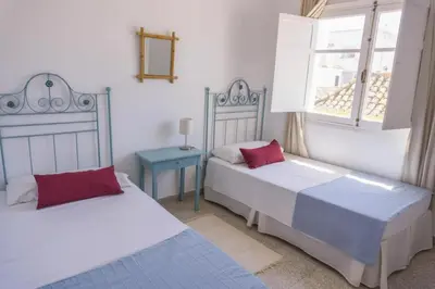 a bedroom with two beds and a window at Magnifico alojamiento a 14 metros de la playa con magnificas vistas in Chipiona