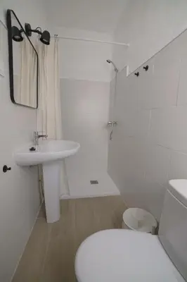 a white bathroom with a toilet and a sink at Magnifico alojamiento a 14 metros de la playa con magnificas vistas in Chipiona