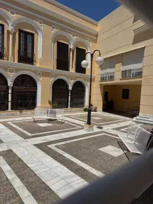 a building with two benches and a street light at Apartamento Los Pajaritos II in Jerez de la Frontera