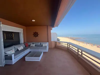 a living room with a couch and a view of the beach at Mirador de Sanlucar 2 in Sanlúcar de Barrameda