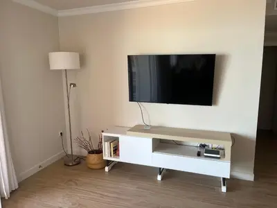a white entertainment center with a flat screen tv on a wall at Mirador de Sanlucar 2 in Sanlúcar de Barrameda