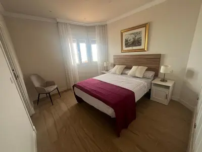 a bedroom with a bed and a chair at Mirador de Sanlucar 2 in Sanlúcar de Barrameda
