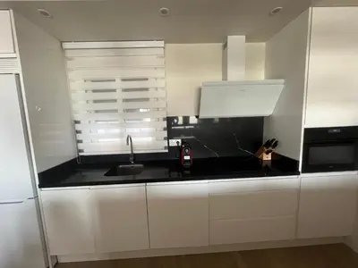 a kitchen with white cabinets and a black counter top at Mirador de Sanlucar 2 in Sanlúcar de Barrameda