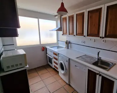 a kitchen with a sink and a washing machine at Ático con espléndida terraza in Cádiz