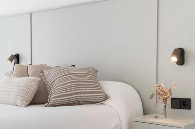 a white couch with a striped pillow and a table at Casa Aura in Novo Sancti Petri