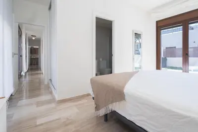 a white bedroom with a large bed and a window at Casa Aura in Novo Sancti Petri