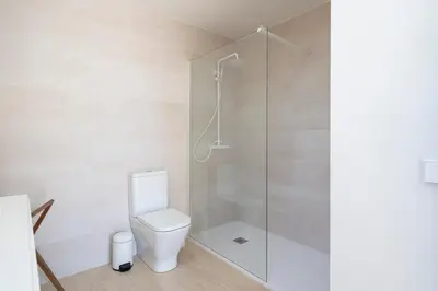 a bathroom with a toilet and a glass shower at Casa Aura in Novo Sancti Petri