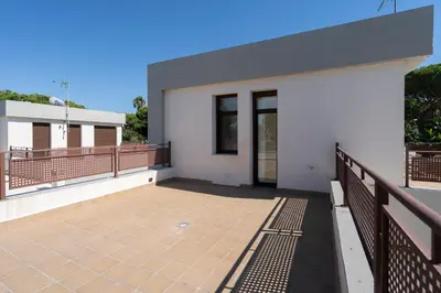 a white house with a balcony and a fence at Casa Aura in Novo Sancti Petri