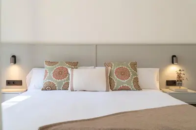 a bedroom with a white bed with pillows at Casa Aura in Novo Sancti Petri