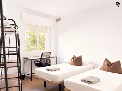 a bedroom with two beds and a desk and a ladder at Apartamento La Caleta Grupo AC Gestion in Cádiz